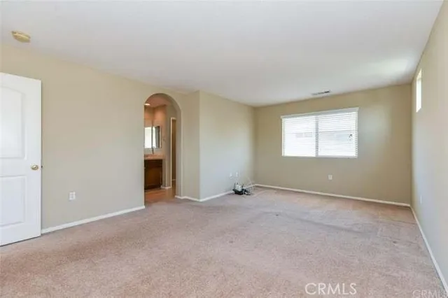 an empty room with windows and bathroom