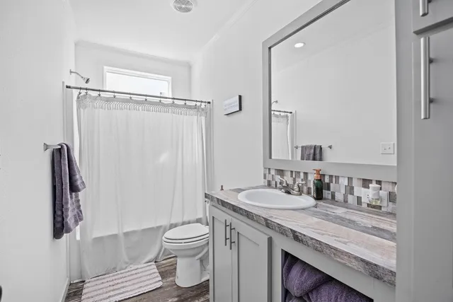 a bathroom with a granite countertop sink toilet and shower
