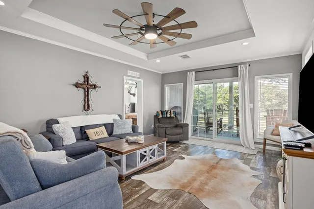 a living room with furniture a flat screen tv and a large window