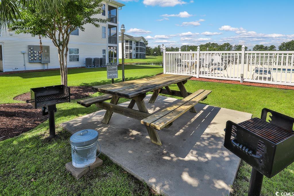 673 Tupelo Lane, Unit 19H Longs, SC 29568 - Photo 12 of 22 View of property's community featuring a lawn, a patio area, and outdoor dining area