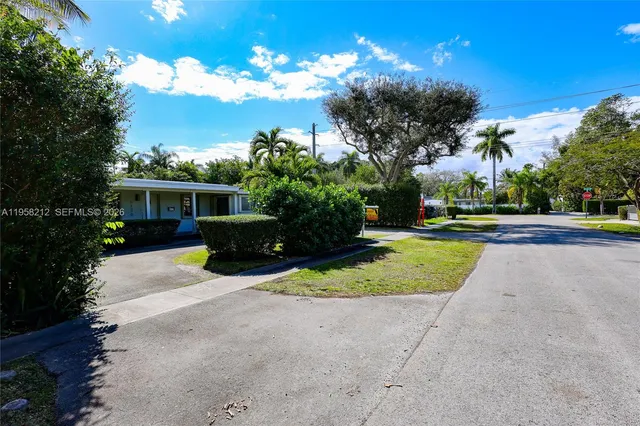 a view of a house with a yard and pathway
