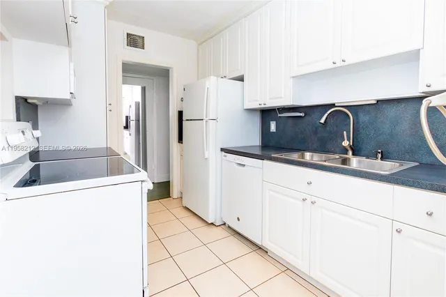 a kitchen with granite countertop a sink and a refrigerator