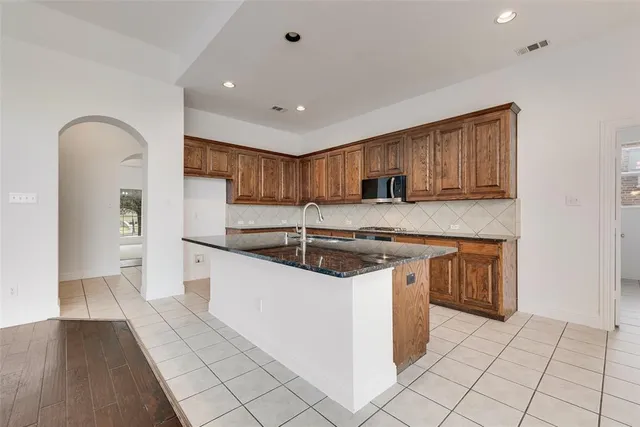 a kitchen with stainless steel appliances granite countertop a stove a sink and a refrigerator