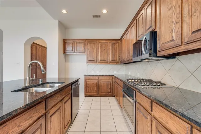 a kitchen with stainless steel appliances granite countertop a sink stove and cabinets