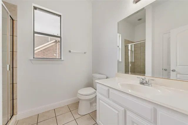 a bathroom with a toilet a sink a mirror and a shower