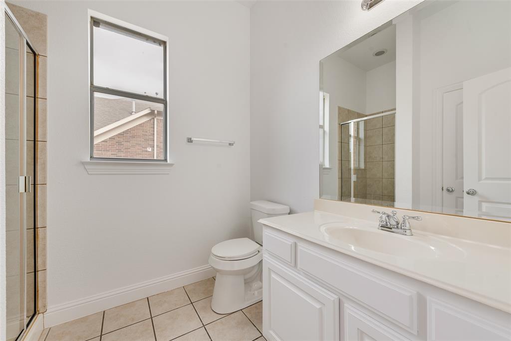 413 Kearsarge Street DeSoto, TX 75115 - Photo 15 of 33 a bathroom with a toilet a sink a mirror and a shower