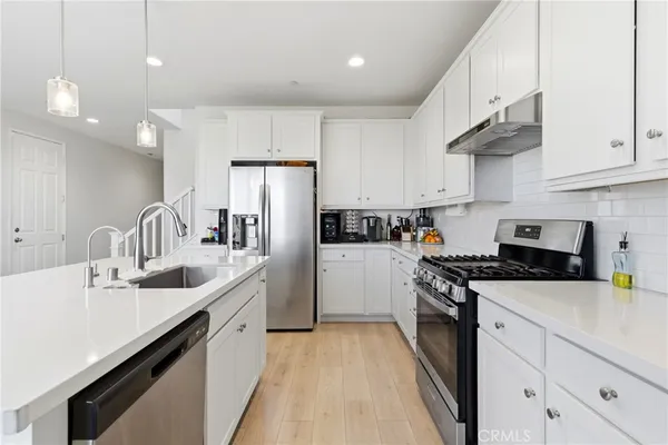 a kitchen with granite countertop a sink stainless steel appliances and cabinets