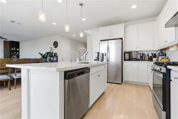 a kitchen with kitchen island a sink appliances and cabinets