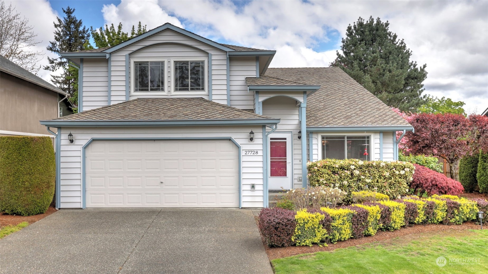 a front view of a house with a yard and garage