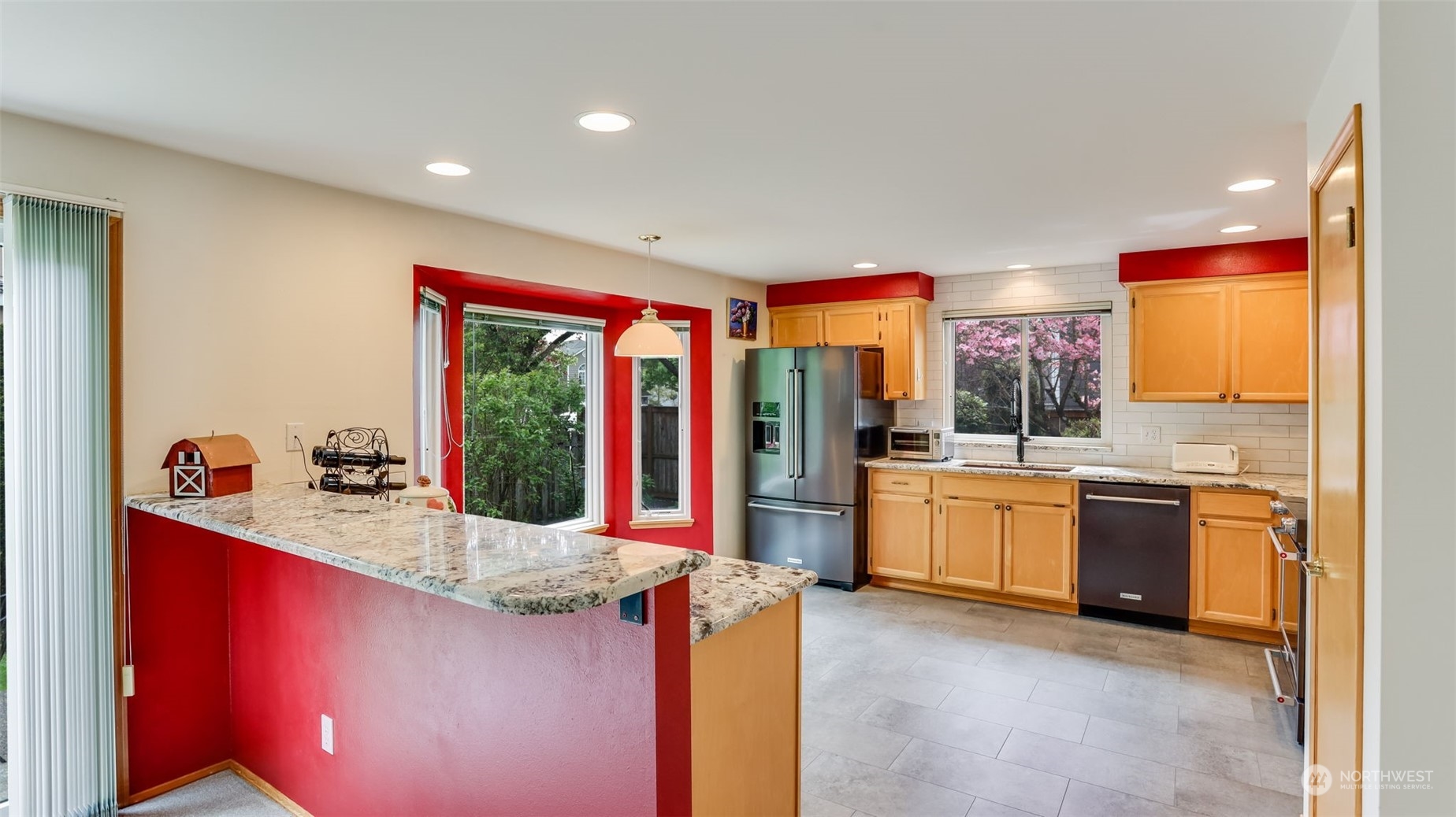 27728 211th Court Southeast Maple Valley, WA 98038 - Photo 4 of 23 a kitchen with stainless steel appliances kitchen island granite countertop a stove a sink and a refrigerator