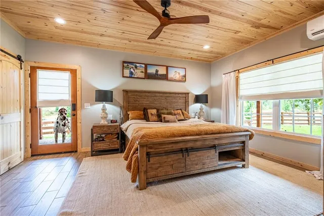 a bedroom with a large bed and wooden floor