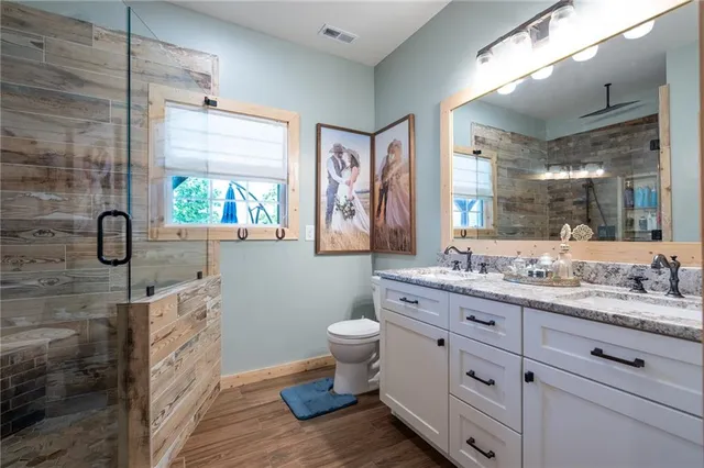 a bathroom with a double vanity sink toilet and a shower