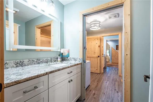 a en suite bathroom with a granite countertop sink mirror and a toilet