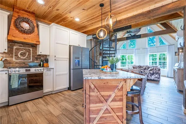 a kitchen with stainless steel appliances granite countertop a stove and a wooden floors