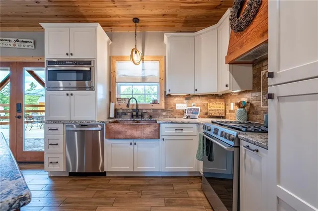 a kitchen with stainless steel appliances granite countertop a stove a sink and a refrigerator