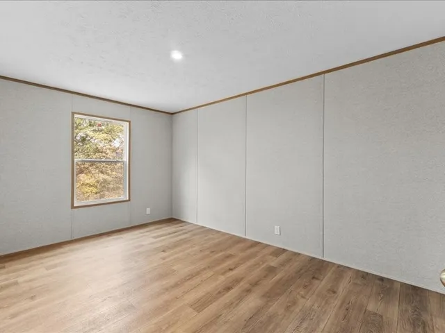 a view of an empty room with a window and closet
