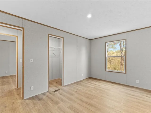 an empty room with windows and closet