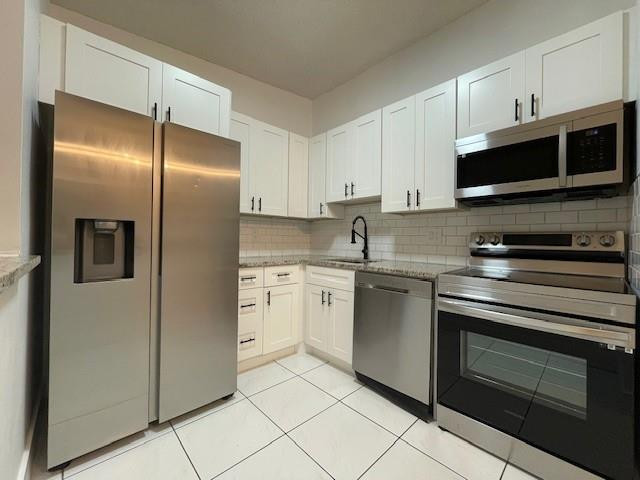 9499 West McNab Road, Unit 208 Tamarac, FL 33321 - Photo 19 of 19 a kitchen with stainless steel appliances granite countertop a refrigerator stove a sink and a microwave