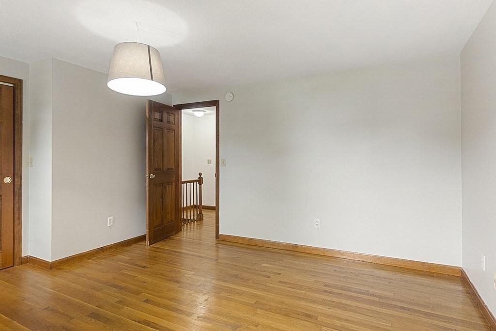 120 Birch Street Boston, MA 02131 - Photo 15 of 42 a view of an empty room with wooden floor and a window