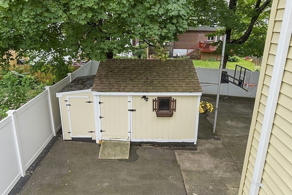 120 Birch Street Boston, MA 02131 - Photo 32 of 42 a view of a patio with table and chairs with wooden fence and floor