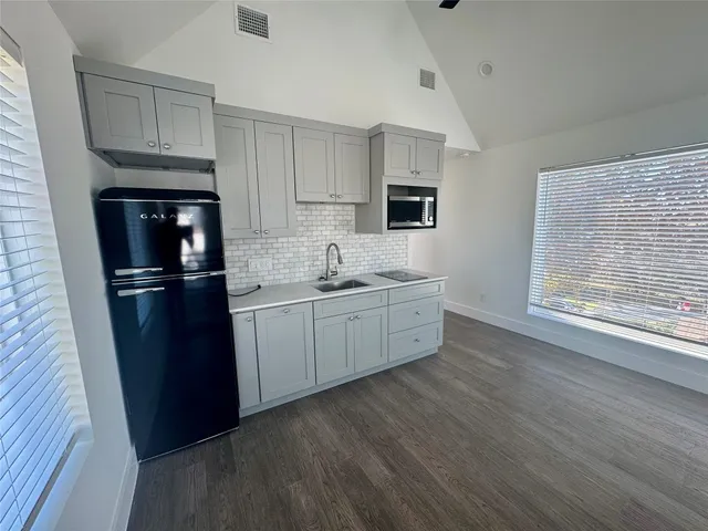 a kitchen with a refrigerator sink and cabinets