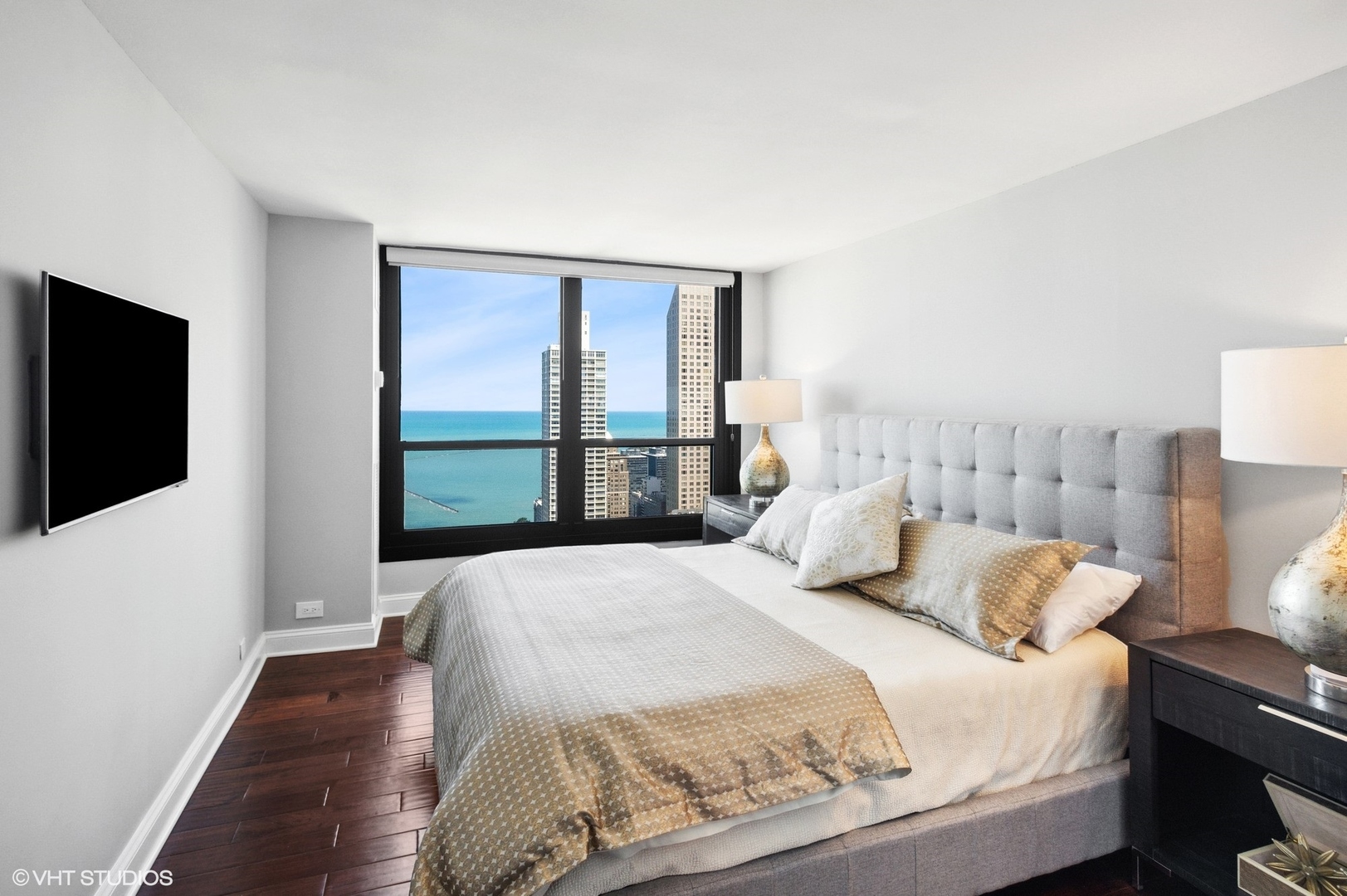 1030 North State Street, Unit 44E Chicago, IL 60610 - Photo 13 of 22 a bedroom with a large bed and a flat tv screen on dresser