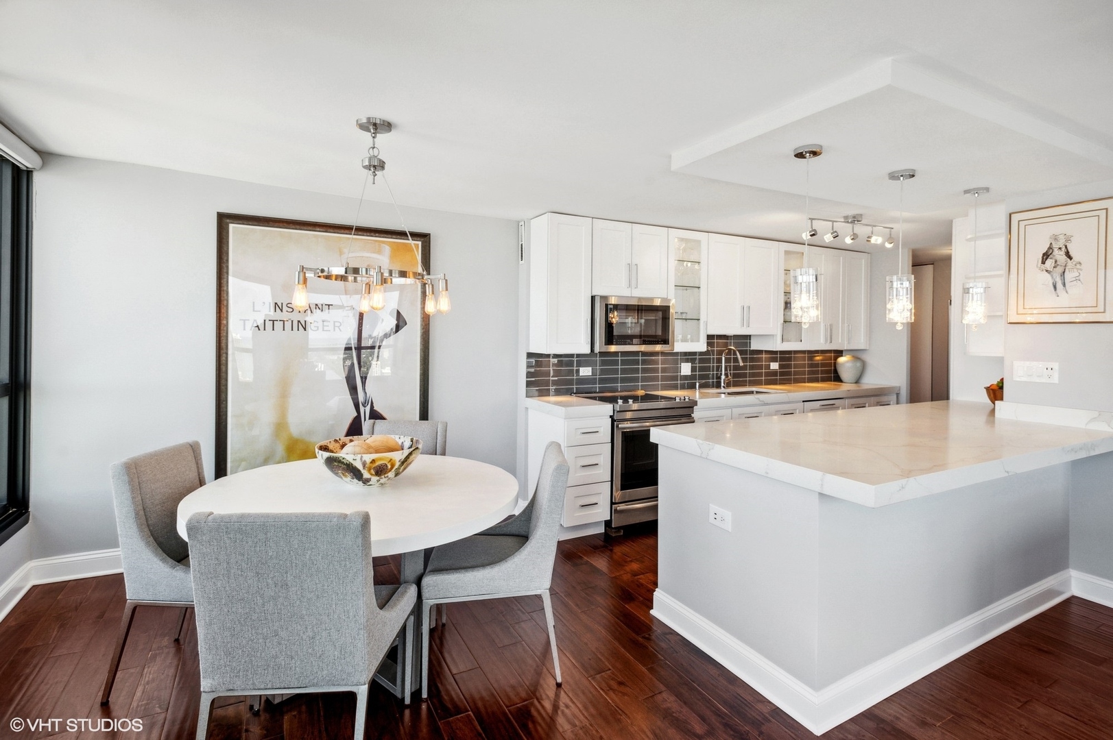 1030 North State Street, Unit 44E Chicago, IL 60610 - Photo 7 of 22 a kitchen with stainless steel appliances kitchen island a table chairs and a refrigerator