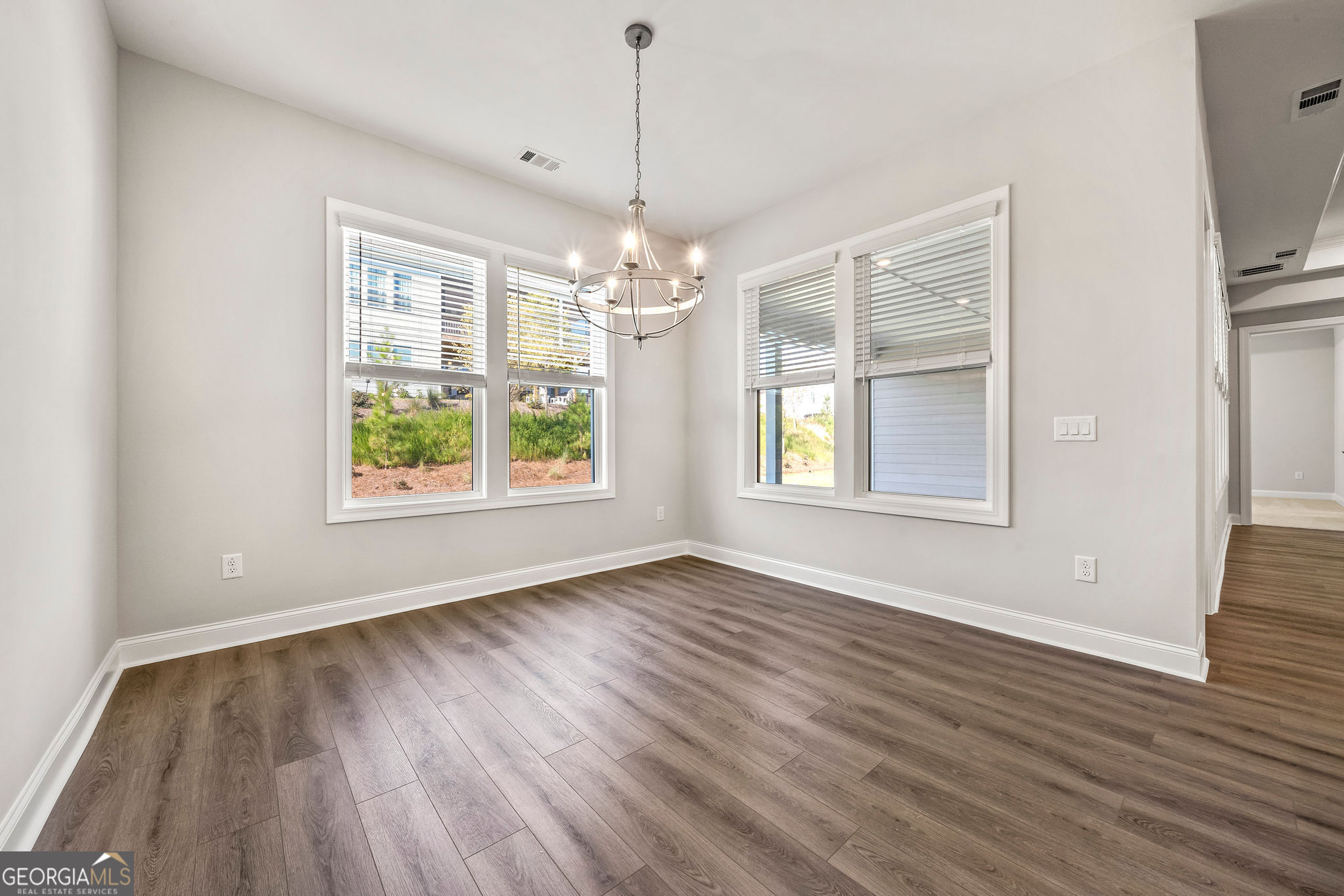 68 Ballyfin Way Newnan, GA 30263 - Photo 23 of 46 an empty room with wooden floor chandelier and windows
