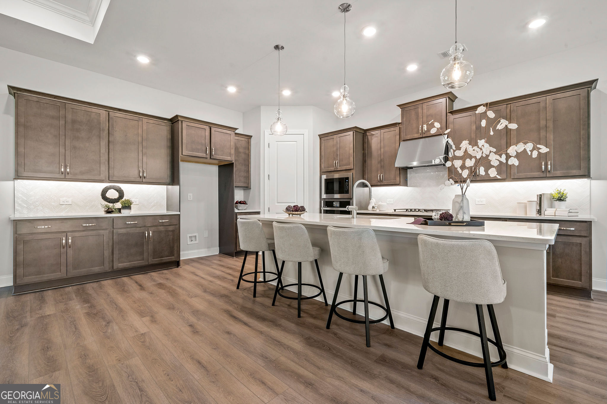 68 Ballyfin Way Newnan, GA 30263 - Photo 3 of 46 a kitchen with stainless steel appliances kitchen island granite countertop a sink a stove a refrigerator and a microwave with wooden floor