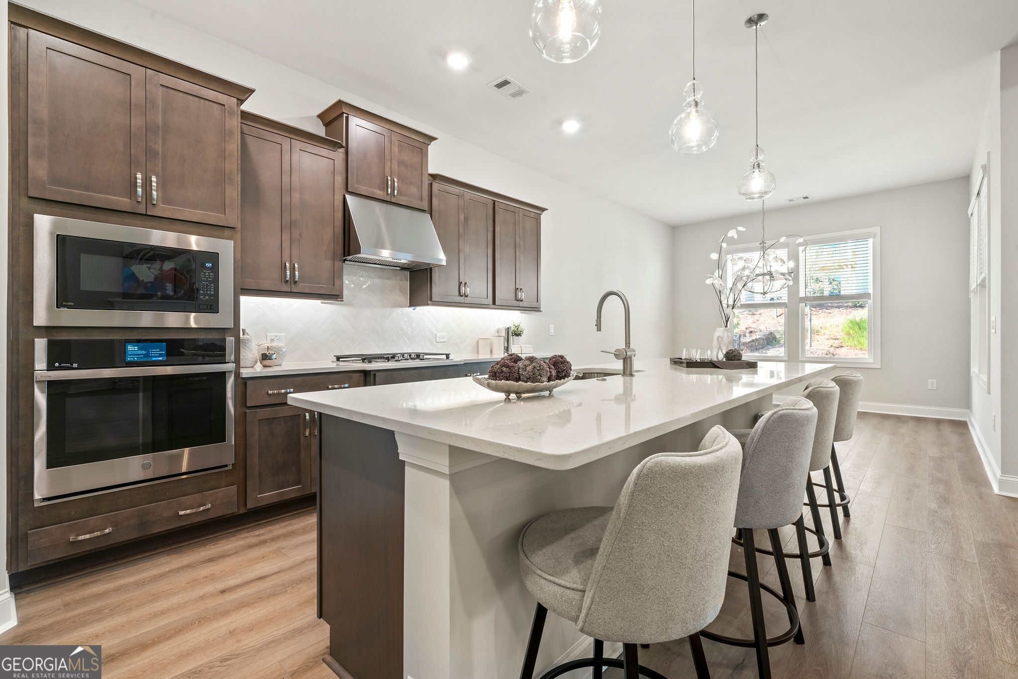 68 Ballyfin Way Newnan, GA 30263 - Photo 6 of 46 a kitchen with stainless steel appliances granite countertop a sink a stove a refrigerator cabinets and a dining table with wooden floor