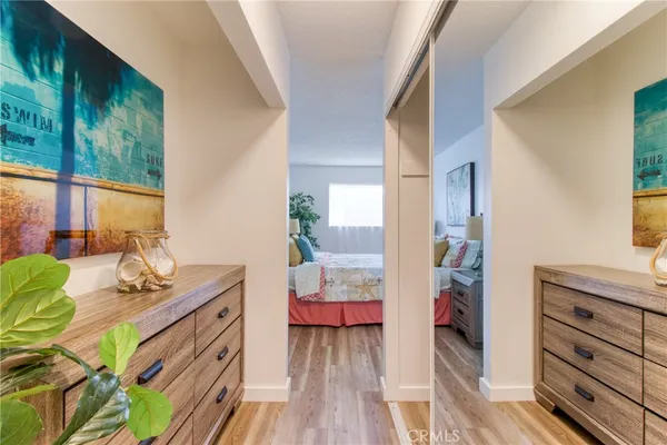 a bedroom with a bed and a dresser next to a window