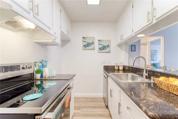 a kitchen with stainless steel appliances granite countertop a sink and a stove