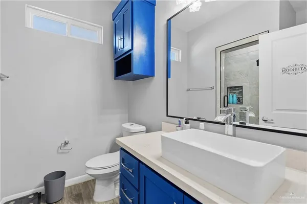 a bathroom with a sink a toilet and a mirror