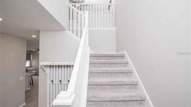 a view of staircase with white walls and a window