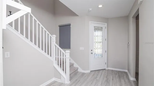 a view of a hallway with wooden floor and entryway