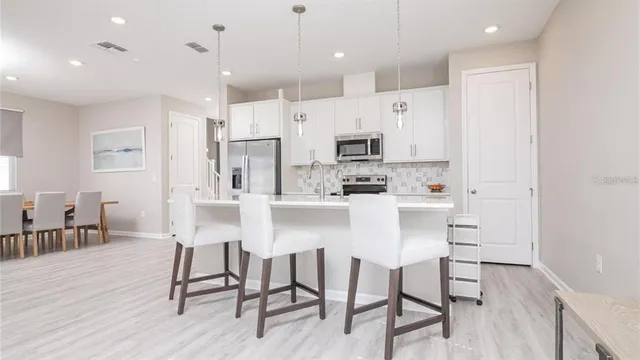 a kitchen with kitchen island wooden cabinets and refrigerator