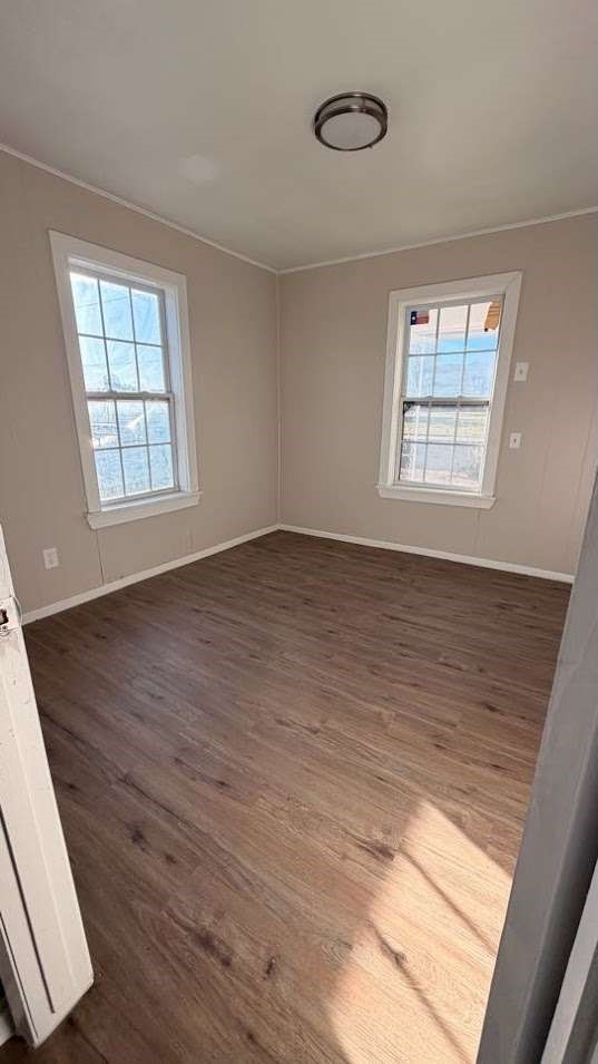 2414 Baylor Street Lubbock, TX 79415 - Photo 6 of 9 a view of an empty room with wooden floor and a window