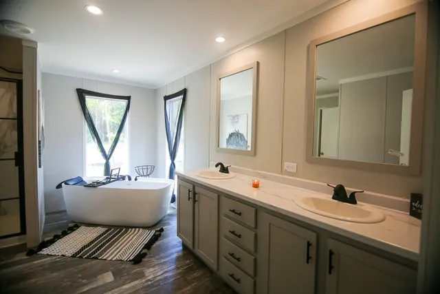 a en suite bathroom with a bathtub sink and mirror