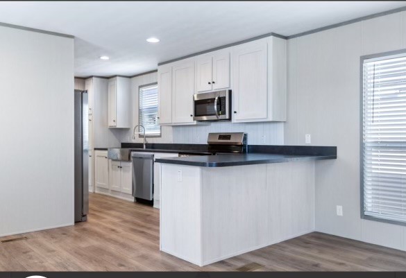 4343 Katy Hockley Road, Unit 162 Katy, TX 77493 - Photo 3 of 8 a kitchen with stainless steel appliances granite countertop a stove a sink and a microwave