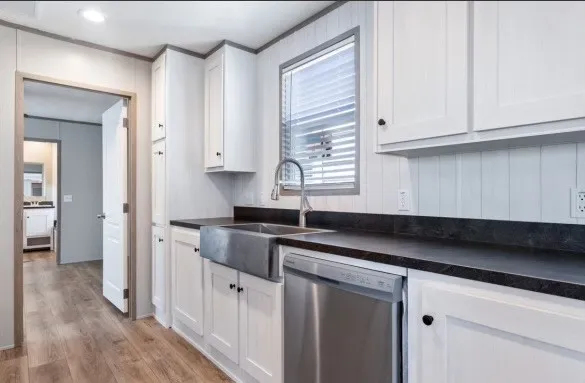 a kitchen with granite countertop white cabinets and sink