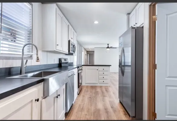 a kitchen with white cabinets and stainless steel appliances
