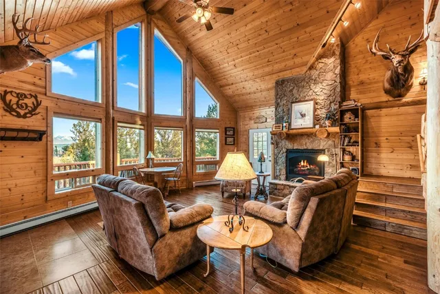 a living room with furniture a fireplace and a floor to ceiling window