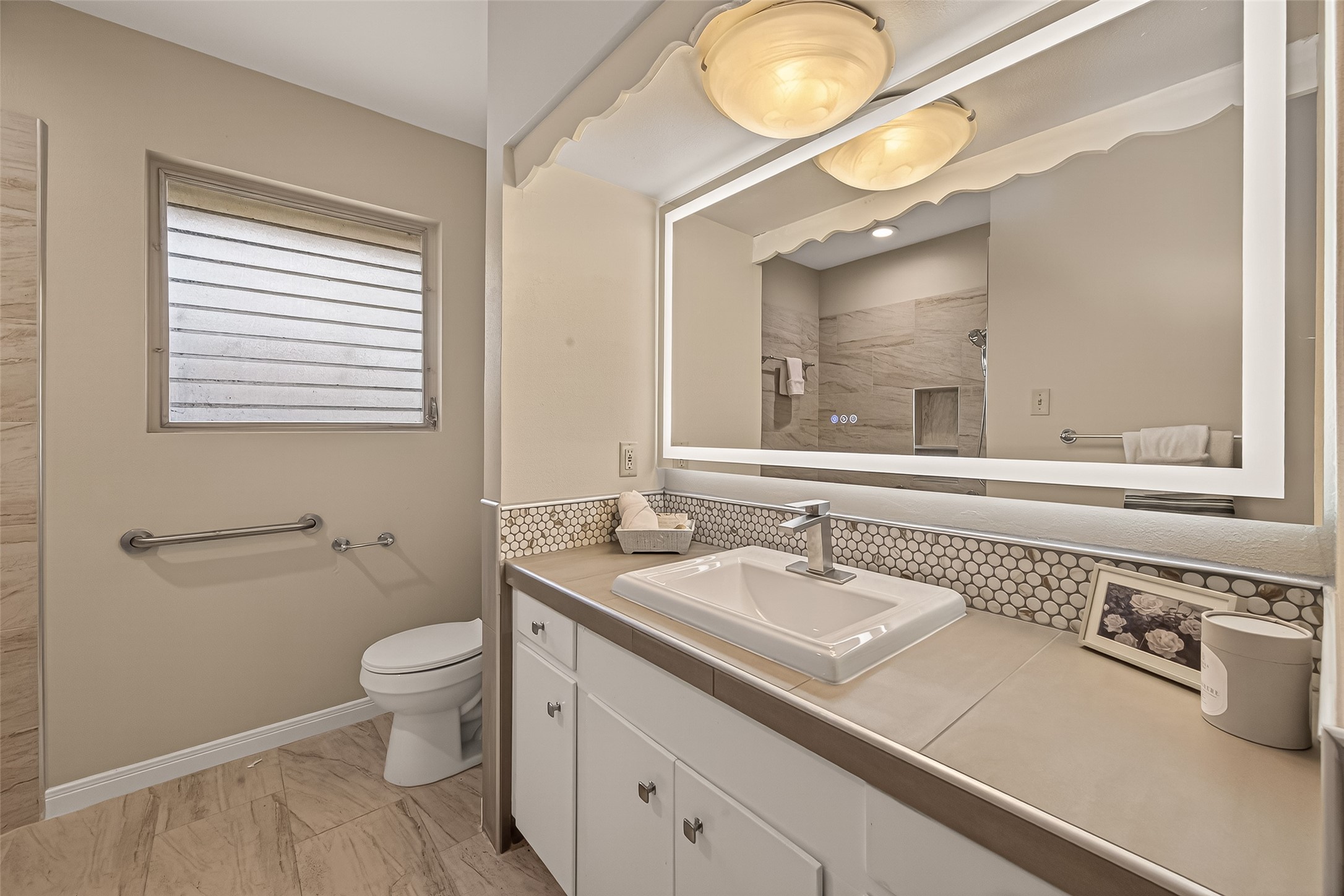 5646 Hazen Street Houston, TX 77081 - Photo 30 of 43 The bathrooms have been completely upgraded with sleek porcelain countertops, a large illuminated mirror and tiled accents.