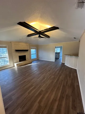 a view of empty room with wooden floor and fireplace