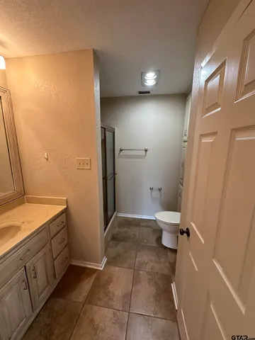 a bathroom with a granite countertop sink toilet and shower