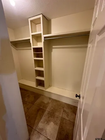 a view of walk in closet with empty racks
