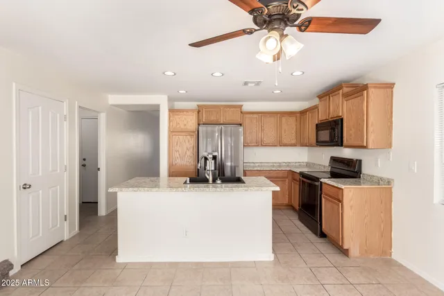 a kitchen with stainless steel appliances granite countertop a sink and a stove