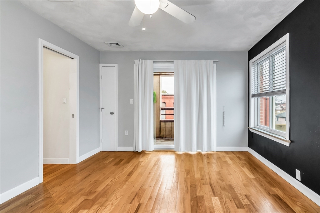 21 Margin Street, Unit 33 Lynn, MA 01905 - Photo 15 of 30 a view of an empty room with wooden floor and a window