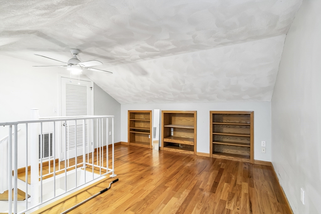 21 Margin Street, Unit 33 Lynn, MA 01905 - Photo 25 of 30 a view of a bedroom with wooden floor and windows