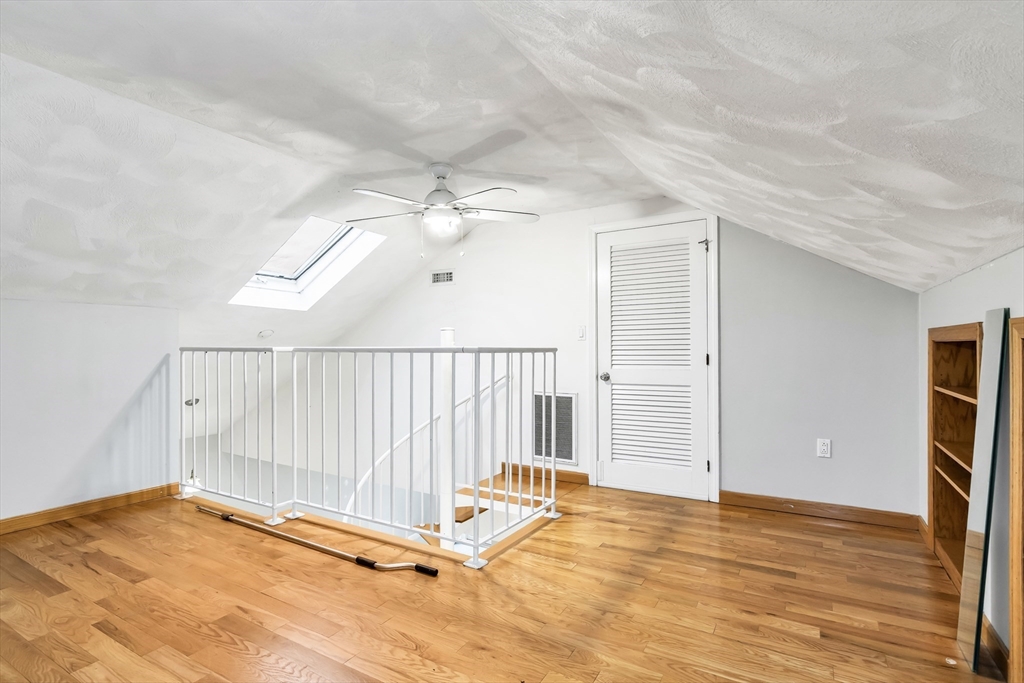 21 Margin Street, Unit 33 Lynn, MA 01905 - Photo 26 of 30 an empty room with wooden floor and windows